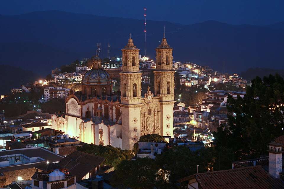 Santa Prisca glowing above Taxco at dusk